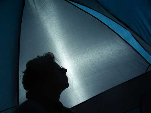 Head of person sillouetted inside tent