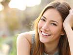 Benefits of Sleep Article Photo - Young woman smiling.
