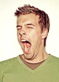 Man in green shirt yawning.