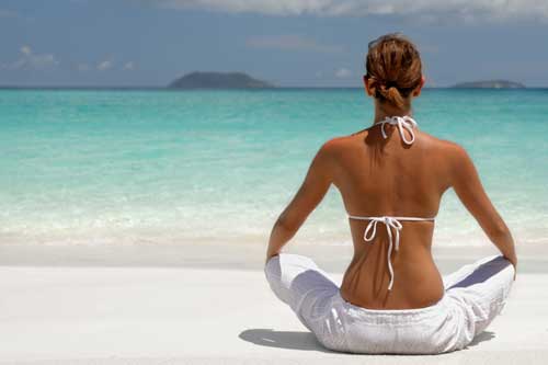 Woman meditating on beach