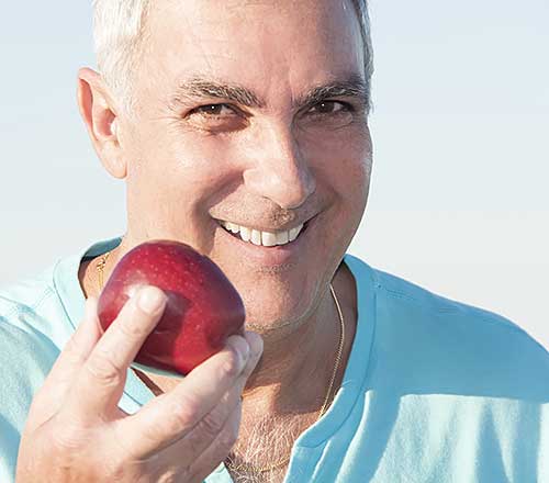 Mature man holding red apple
