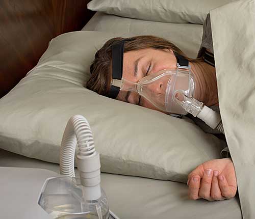 Lady with obstructive sleep apnea wearing CPAP mask