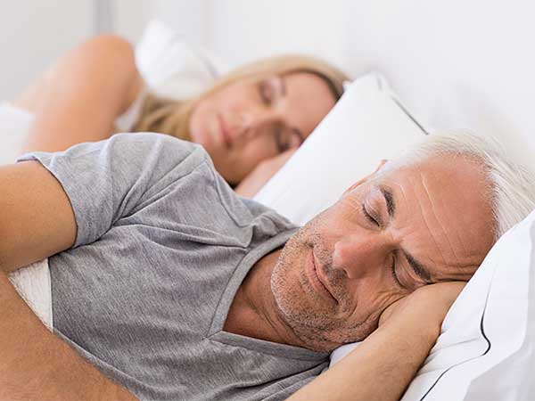 Mature man and woman sleeping.
