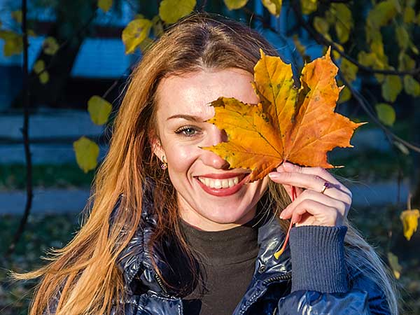 Cheerful lady holding leaf.