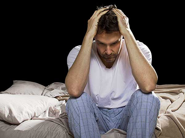 Man suffering from sleep anxiety.