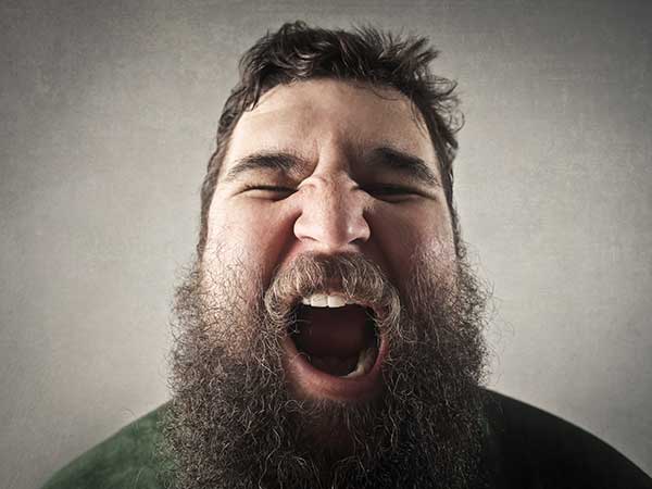 Overweight bearded man yawning.