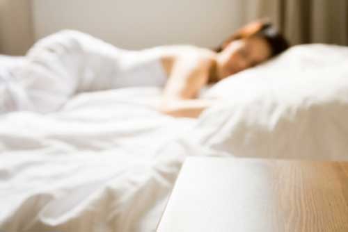Blurred image of woman laying on mattress